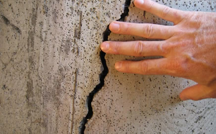 Hand touching a concrete crack